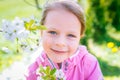 Little laughing girl squinting eyes on a spring background with Royalty Free Stock Photo