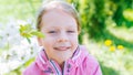 Little laughing girl squinting eyes on a spring background Royalty Free Stock Photo