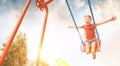 Little laughing girl swing on swing. Happy childchood concept image Royalty Free Stock Photo