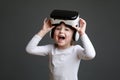 Little laughing girl with virtual reality headset. Innovative technology and education concept Royalty Free Stock Photo