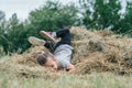 Little laughing girl 3-4 years old jumps and plays in hay stack, on background of trees Royalty Free Stock Photo