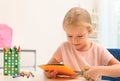 Little left-handed girl cutting construction paper