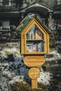 Little library in neighborhood on pole in front yard with Christmas decorations in front of house with snow on ground Royalty Free Stock Photo