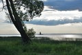 Little lighthouse in the middle of St-Lawrence River at sunset. Dramatic sun light filtering through the clouds. Royalty Free Stock Photo