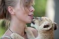 Little lion cub biting girl playing Royalty Free Stock Photo