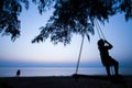 A little local girl playing on the swing on the beach at sunset Royalty Free Stock Photo