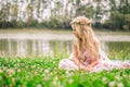 Little lonely girl sitting in the grass by the river Royalty Free Stock Photo