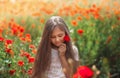 Little longhaired girl  posing at field of poppies with  on summer sun Royalty Free Stock Photo