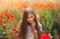 Little longhaired girl  posing at field of poppies with  on summer sun Royalty Free Stock Photo