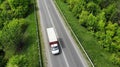 Little lorry driving on the highway, aerial. Green grass and trees on both sides of the road Royalty Free Stock Photo