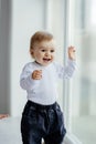 Little, lost in thoughts, and little boy sitting by the window and thinking and waiting for something Royalty Free Stock Photo