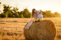 The little lovely boy and his sister in the field with straw sheaves Royalty Free Stock Photo