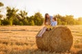 The little lovely boy and his sister in the field with straw sheaves Royalty Free Stock Photo