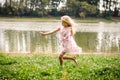 Little lovely girl dancing in the grass by the river Royalty Free Stock Photo