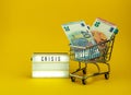 Little metallic cart, Euro banknote and a sign of crise covid Royalty Free Stock Photo