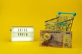 Little metallic cart, a new serie of angloan money/banknote and a sign of crise covid Royalty Free Stock Photo