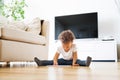 Little mixed-race girl at home playing game on tablet.