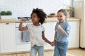 Little mixed race preschool kids enjoying singing songs in kitchen. Royalty Free Stock Photo