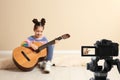 Little music teacher recording guitar lesson