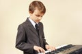 Little musician in suit playing the electronic piano Royalty Free Stock Photo