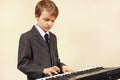 Little musician in suit playing the electronic synthesizer Royalty Free Stock Photo