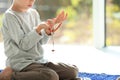 Little Muslim boy with misbaha praying on rug indoors