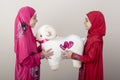 Little Muslim girl give a sheep toy to her friend as a present for Eid Al Adha