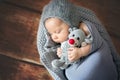 Little newborn baby boy, sleeping in basket, holding toy Royalty Free Stock Photo