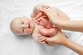 Little newborn baby foot in the hands of mother. adorable child with red kisses on the skin, happy baby on white background. top Royalty Free Stock Photo