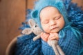 Little newborn baby with a hare closeup and copy space. Newborn photo in a blue diaper. Royalty Free Stock Photo