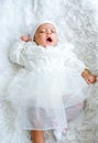 Little newborn baby show action of yawn during lie on white bed