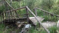 Old wooden mountain bridge over a stream