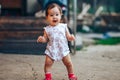 Little one year old girl with dark hair play on yard at home. half-breed girl father is kazakh mother russian caucasian