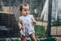 Little one year old girl with dark hair play on yard at home. half-breed girl father is kazakh mother russian caucasian