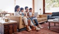 A little online fun. Full length shot of an affectionate young family of four using a laptop while sitting on the sofa Royalty Free Stock Photo