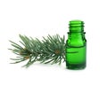 Little open bottle with essential oil and pine branch