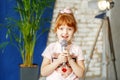 The little ore girl sings to the microphone. The concept is chil Royalty Free Stock Photo