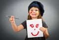 Little painter girl with a drwan smile on grey Royalty Free Stock Photo