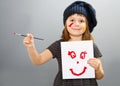 Little painter girl with a drwan smile isolated on grey Royalty Free Stock Photo