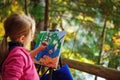 Little painter at work near waterfall