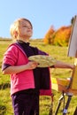 Little painter at work near waterfall Royalty Free Stock Photo