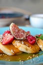 Little pancakes with fruits strawberry, fig, raspberry with caramel souce on plate in restaurant. Breakfast