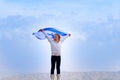 Little patriot jewish girl with the flag of Israel on blue sky background.