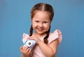 Little photographer with toy camera on light blue