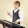 Little pianist in suit playing the electronic piano Royalty Free Stock Photo