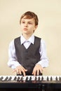 Little pianist in suit playing the electronic synthesizer Royalty Free Stock Photo