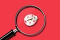 Little piggy bank on a red background. View through a magnifying glass. Decrease in accumulations. Business. Royalty Free Stock Photo