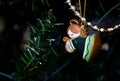 A little plaster Angel, colored in shades of green, little eyes closed, with a harp in her arms, adorns the Christmas Tree Royalty Free Stock Photo