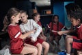 A little player reading autographs on a gypsum of a teammate broken arm. Children team sport