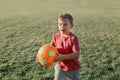 Little preschool Caucasian boy playing soccer football on playground outside. Kid carrying holding ball. Happy authentic candid Royalty Free Stock Photo